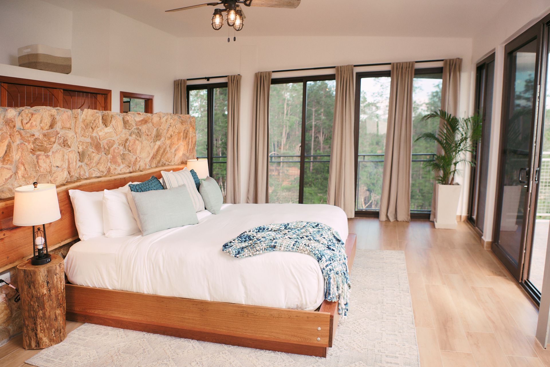 there is a large bed in the middle of the room with a lot of windows .