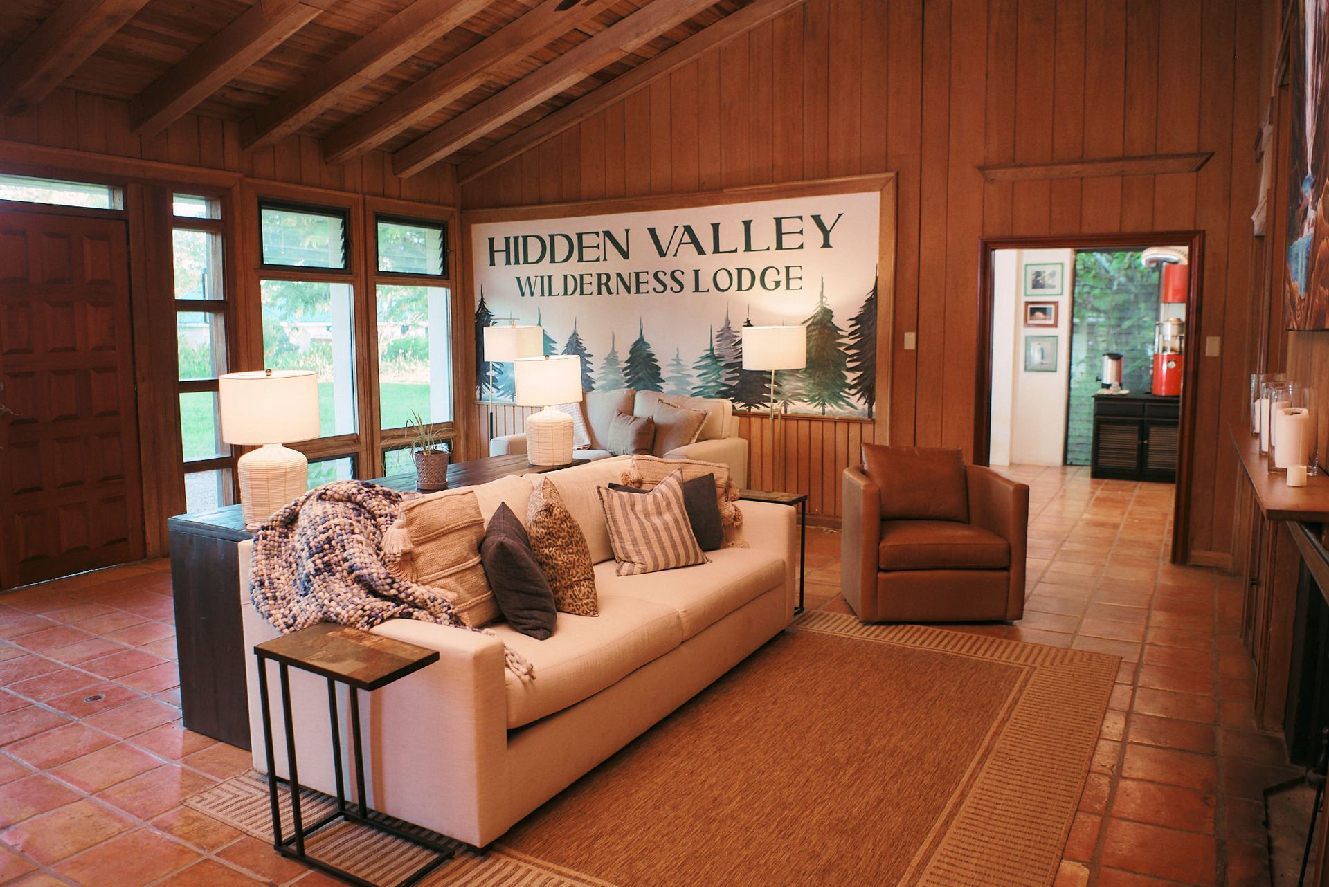 a living room with a couch and chairs and a sign that says hidden valley wilderness lodge