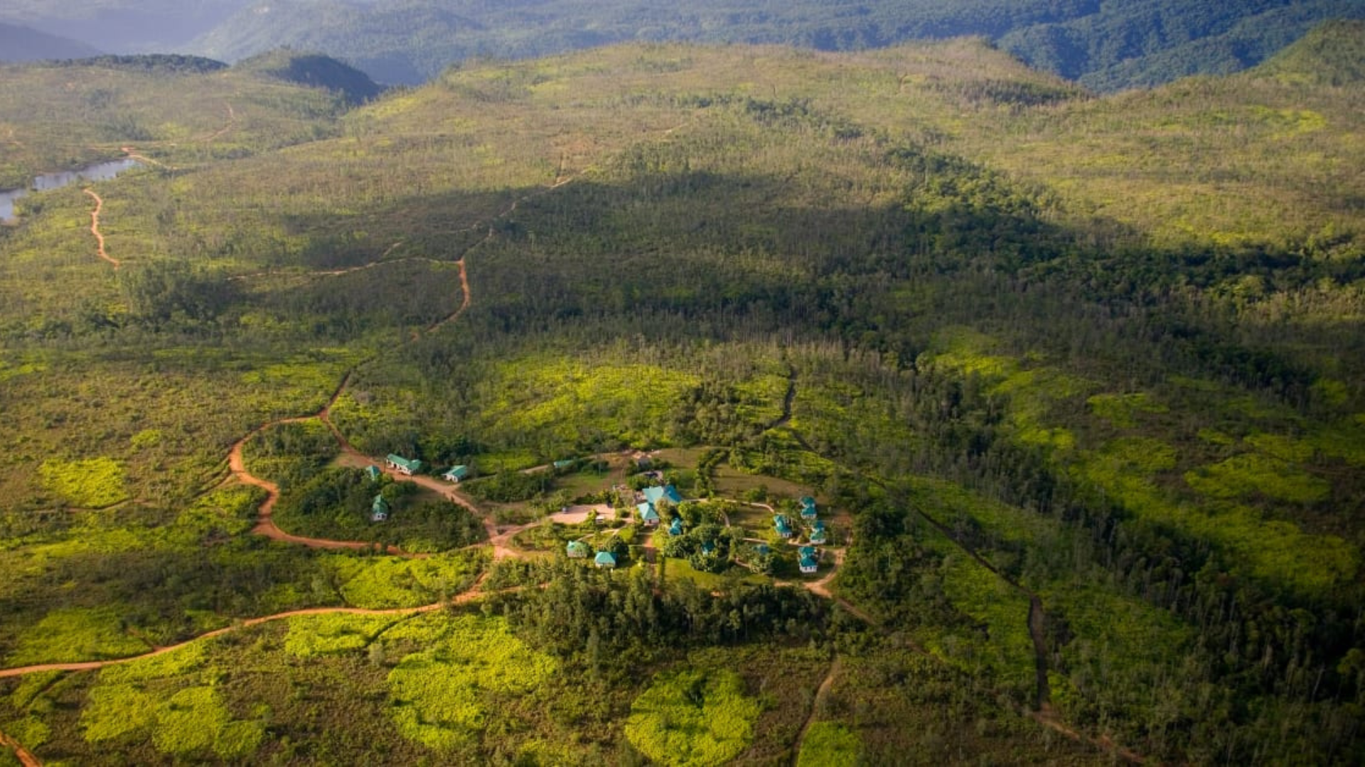 an aerial view of Hidden Valley Wilderness Lodge, lush green forest with a river running through it .