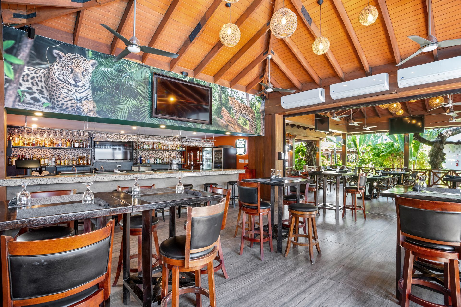 A restaurant with tables and chairs and a bar.