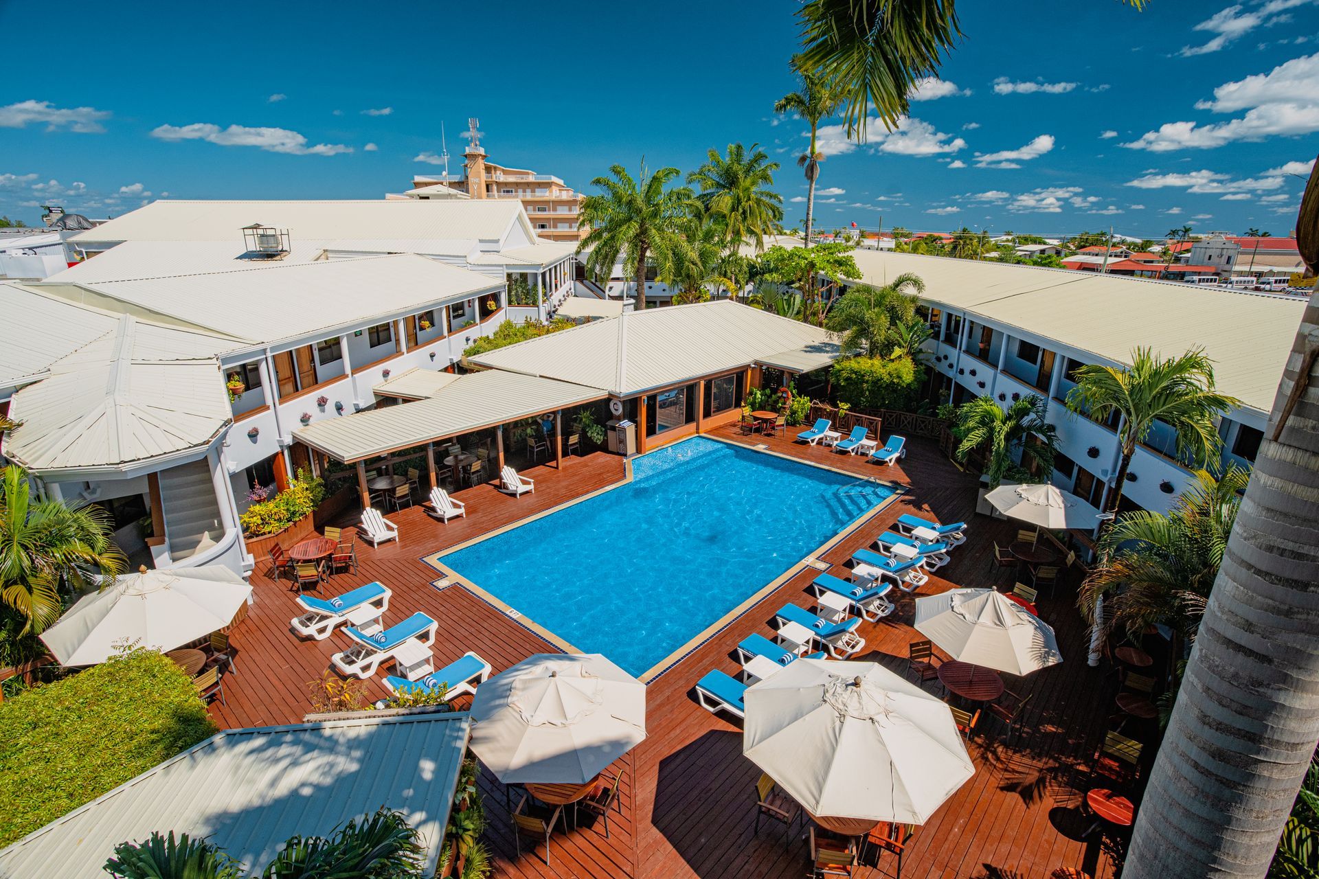 An aerial view of a hotel with a large swimming pool