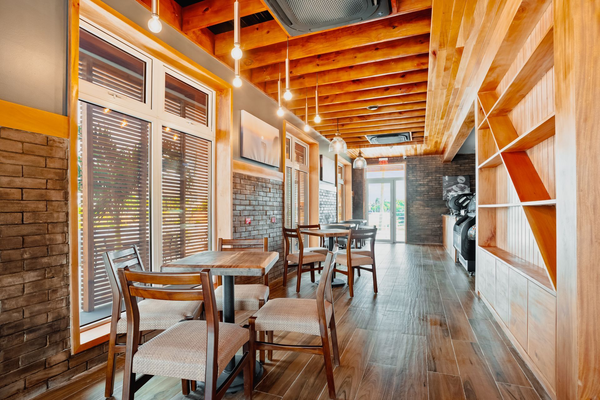 A restaurant with tables and chairs and a wooden floor.