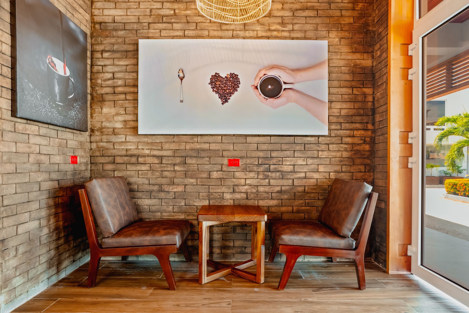 A room with two chairs , a table and a brick wall.