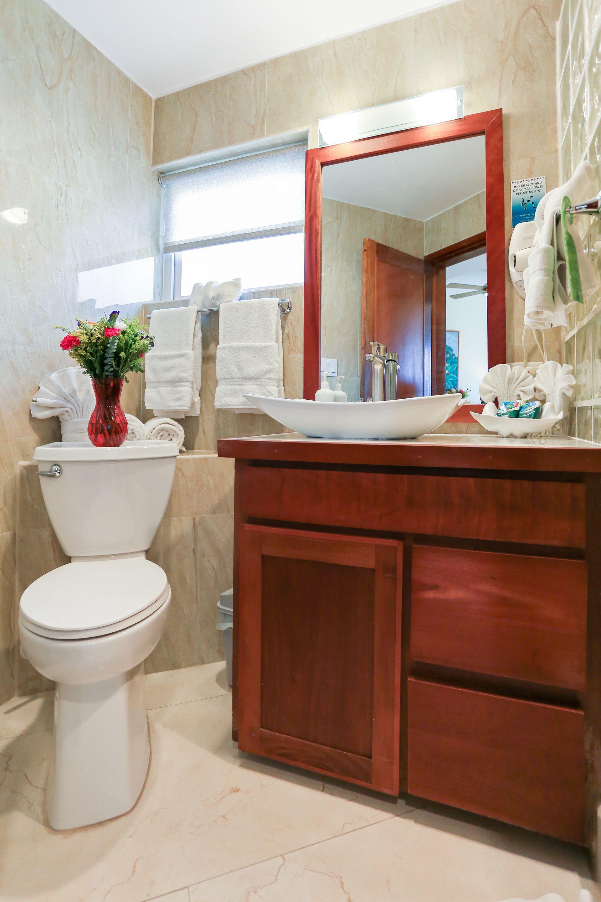 A bathroom with a toilet , sink and mirror.