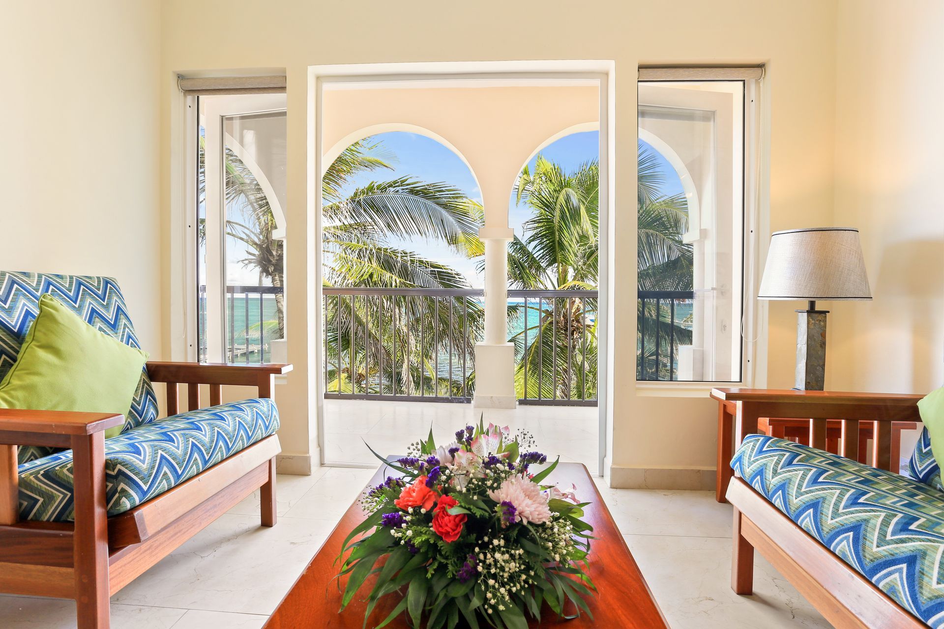A living room with two couches and a coffee table with a bouquet of flowers on it.