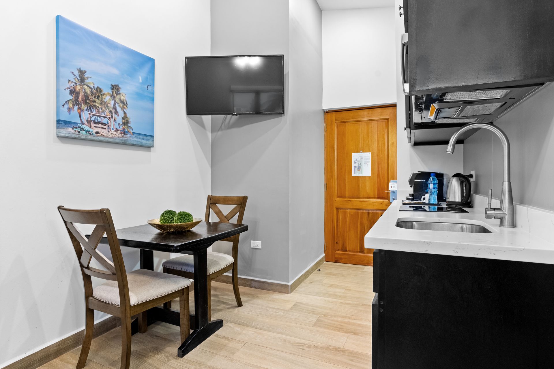 a kitchen with a table and chairs and a flat screen tv .