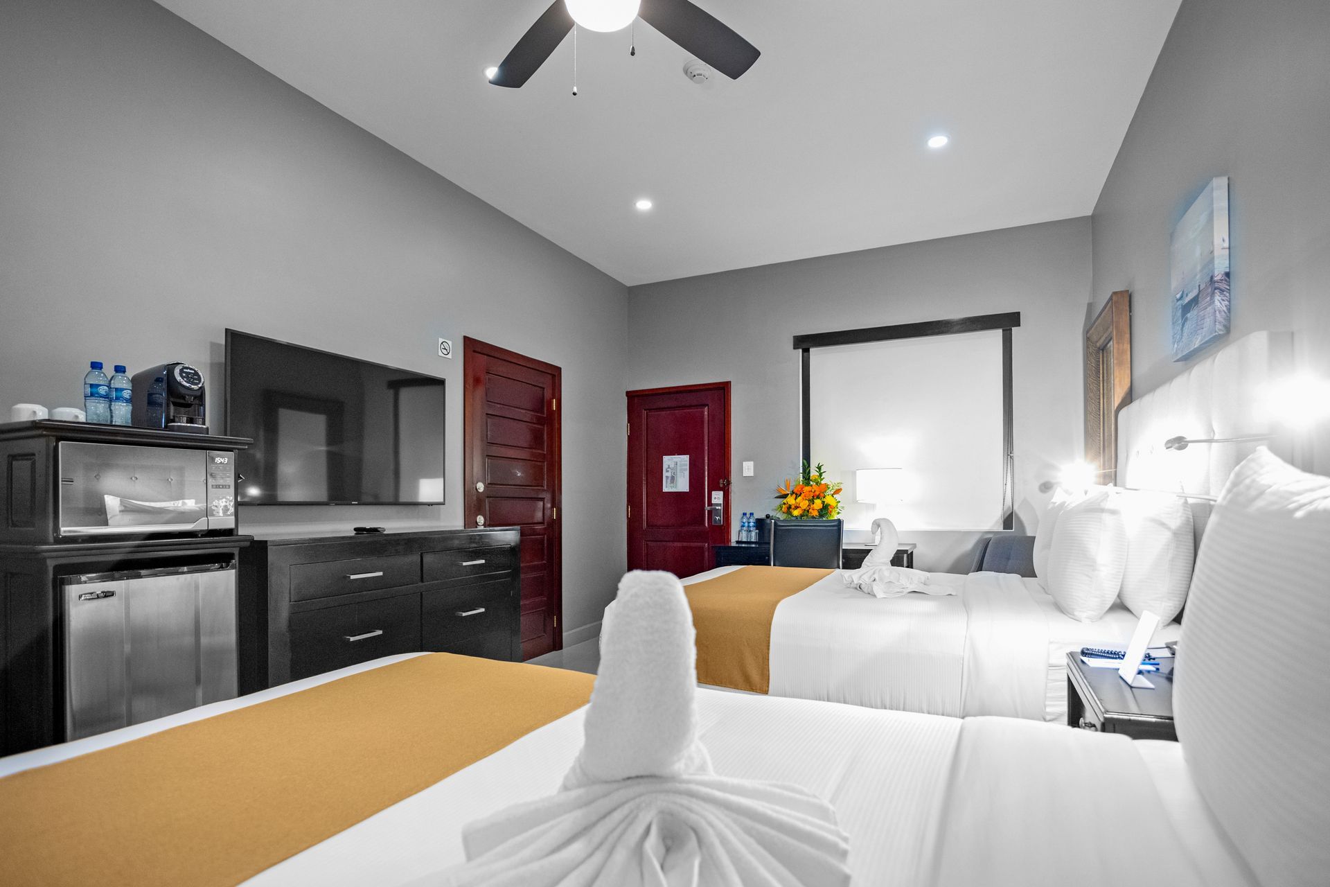 A hotel room with two beds and a ceiling fan.