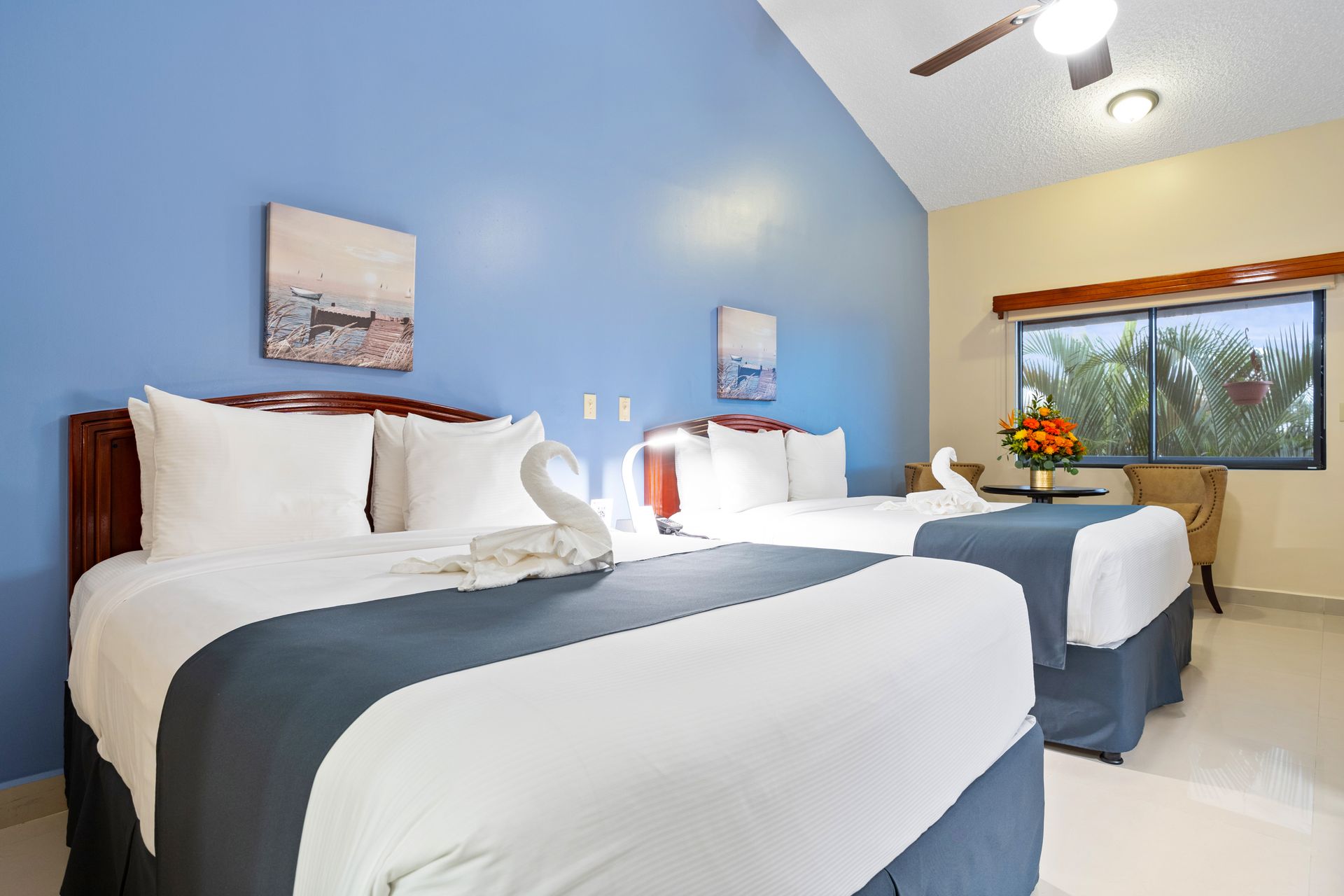 a hotel room with two beds and a ceiling fan