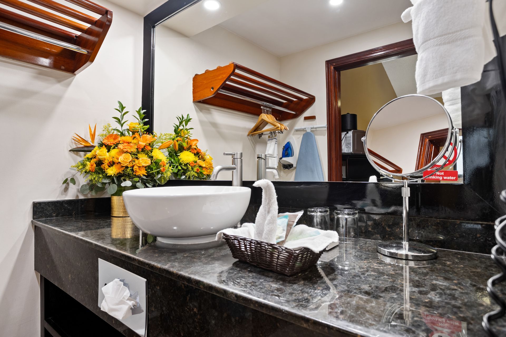 A bathroom in a hotel room with a sink and a mirror.