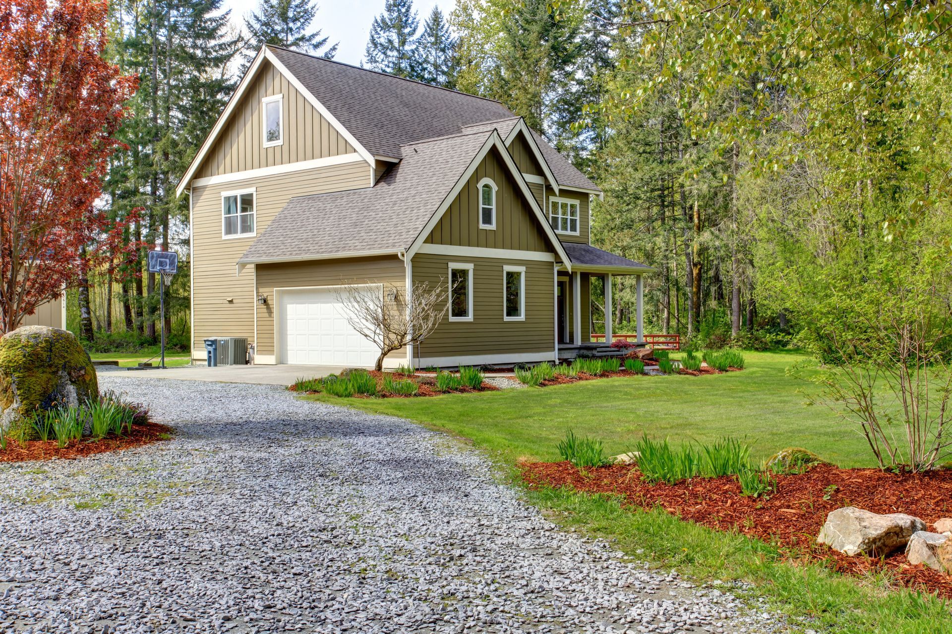 A large house with a gravel driveway leading to it.