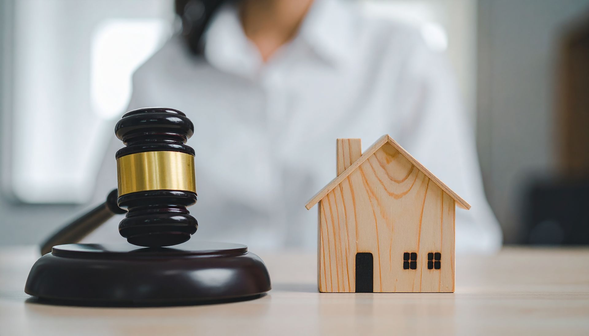 Judge gavel and miniature house on desk. Judge gavel and miniature house on desk.