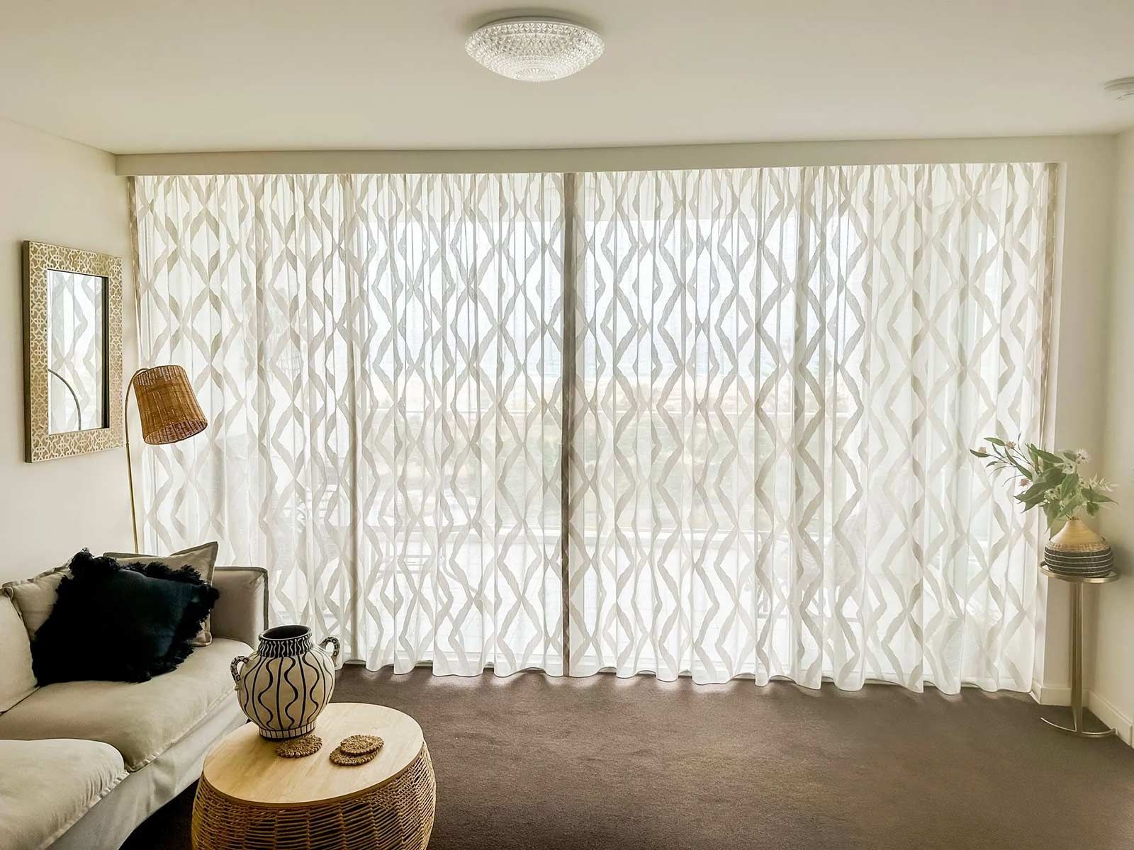 A Living Room with Sliding Glass Doors and White Curtains — Creative Curtains & Blinds In Tweed Heads South, NSW
