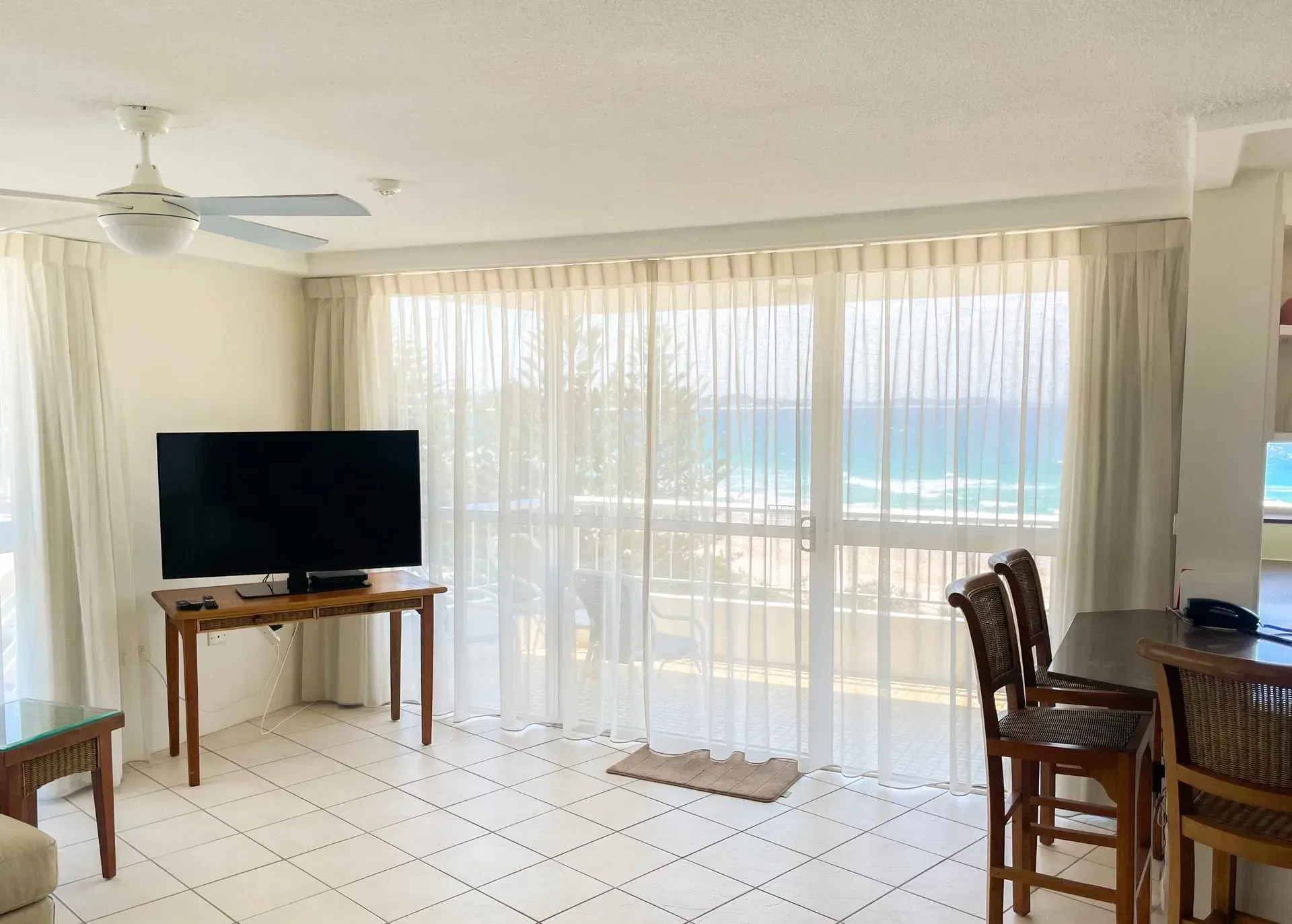 Living Room With A Table And Chairs And A Flat Screen Tv — Creative Curtains & Blinds In Tweed Heads South, NSW 