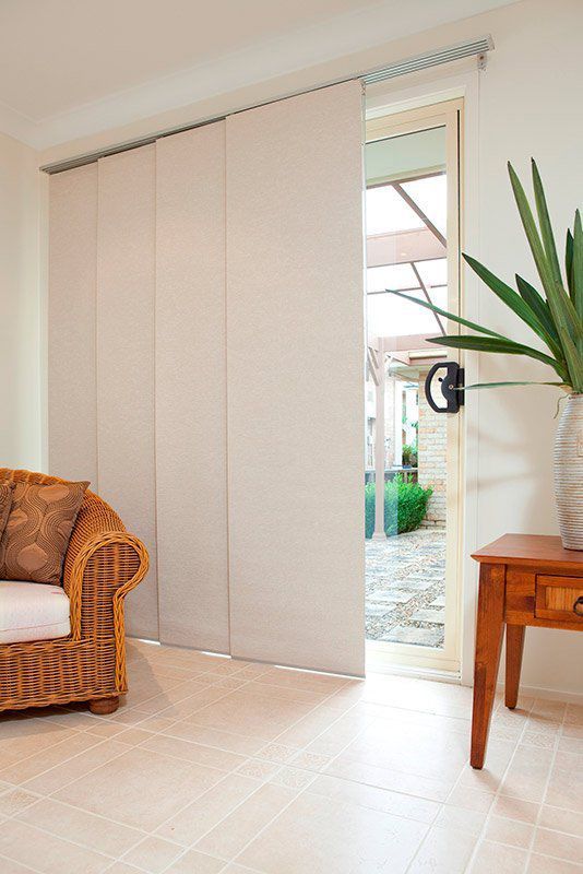 A Living Room with A Wicker Chair and A Table — Creative Curtains & Blinds In Tweed Heads South, NSW