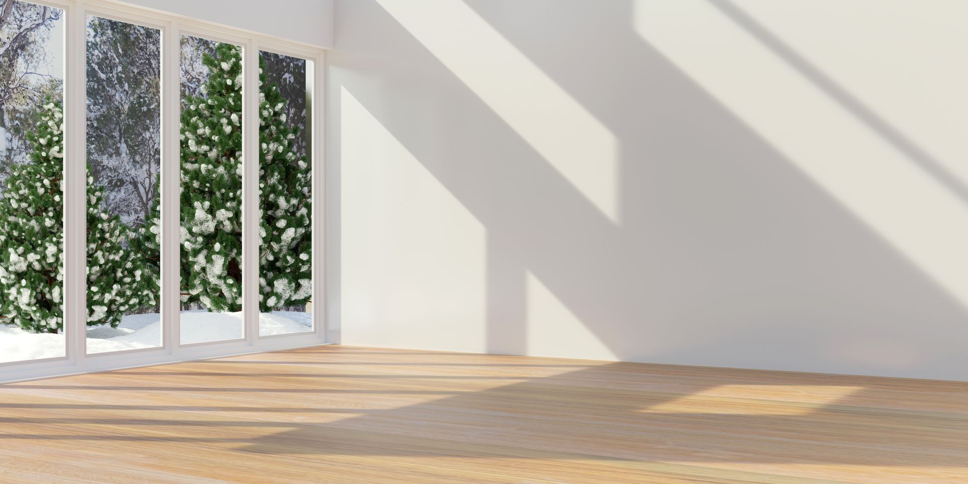Empty room with large windows, sunlight, and a winter view outside.