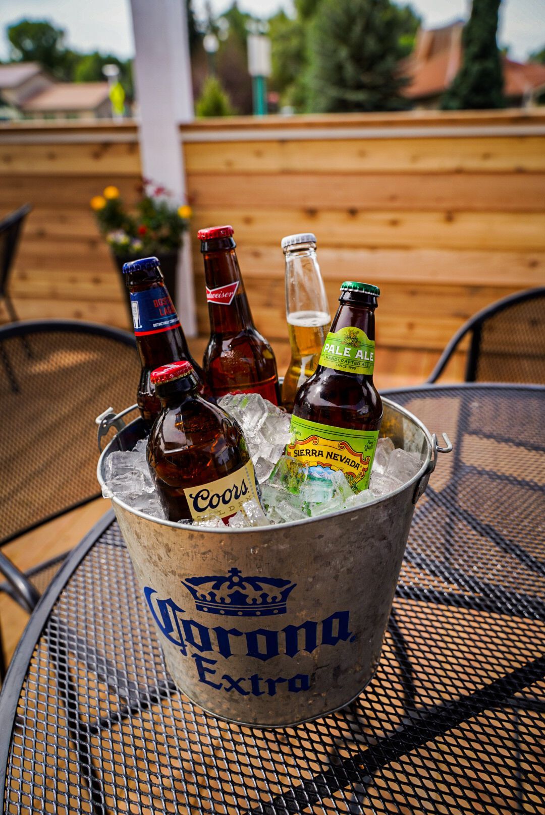 bucket of bottled beer on ice at a table on the patio