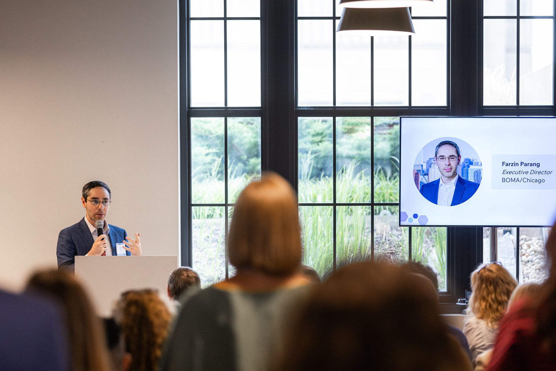 A man is standing at a podium giving a presentation to a group of people.