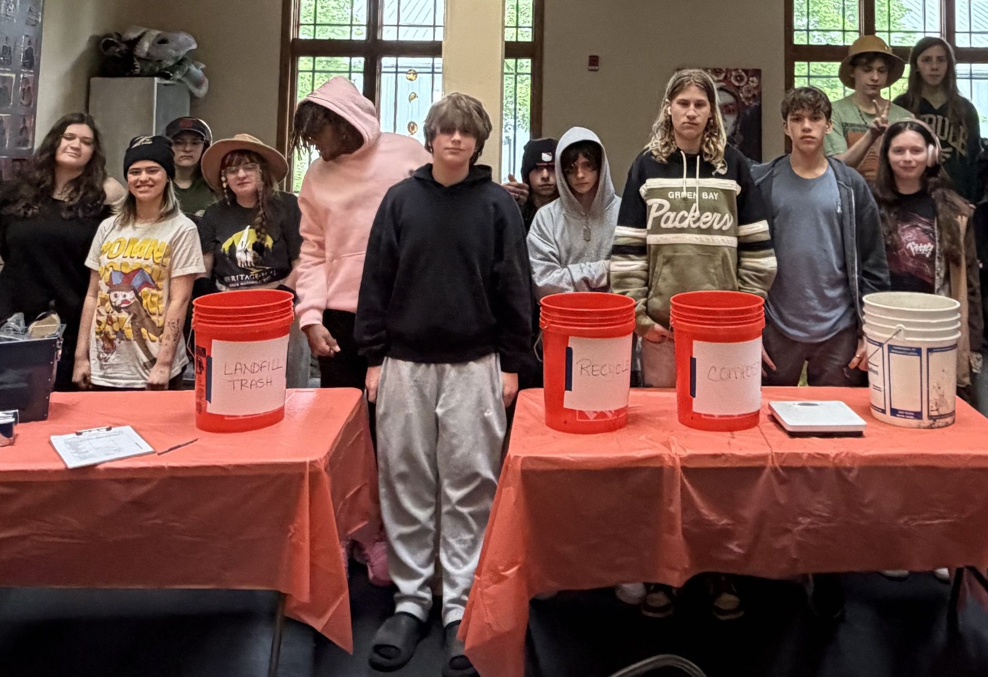 A row of orange buckets are lined up on a table
