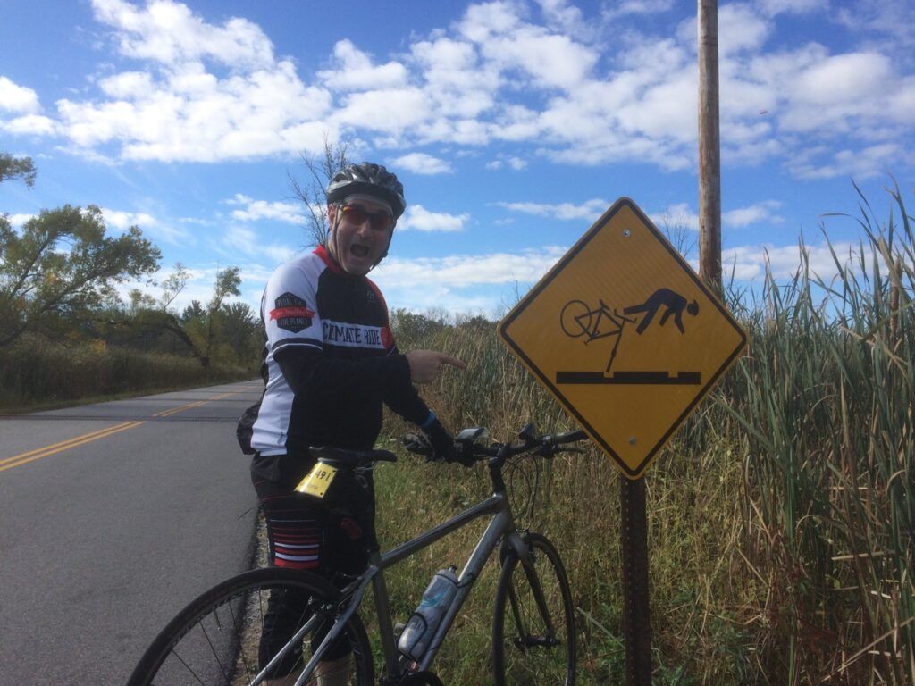 A man riding a bike next to a yellow sign