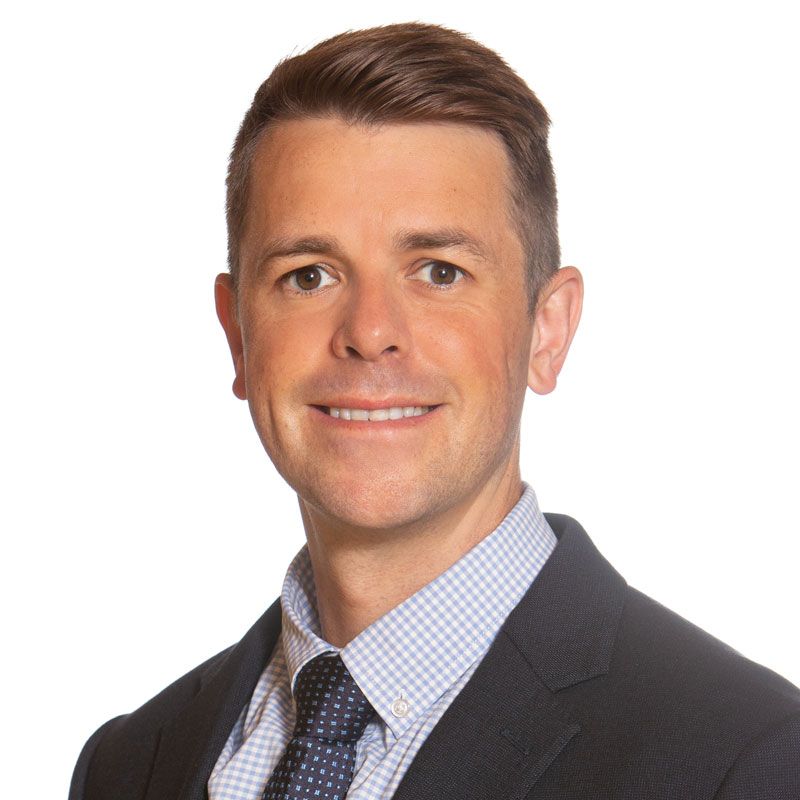 A man in a suit and tie is smiling for the camera.