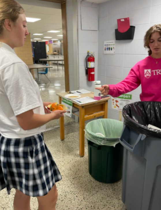 Two girls sorting food waste for compost
