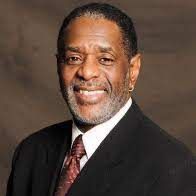 A man in a suit and tie is smiling for the camera.