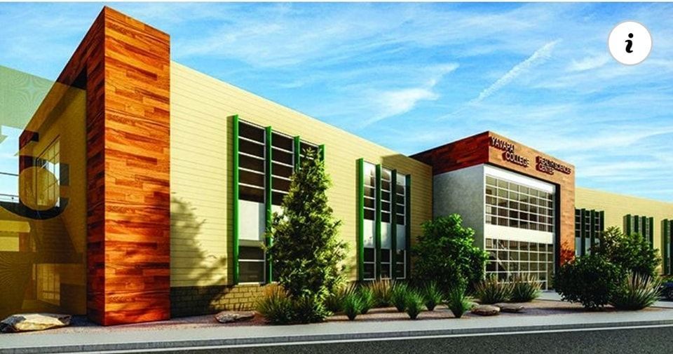 Modern building exterior with wooden accents and windows, under a blue sky.
