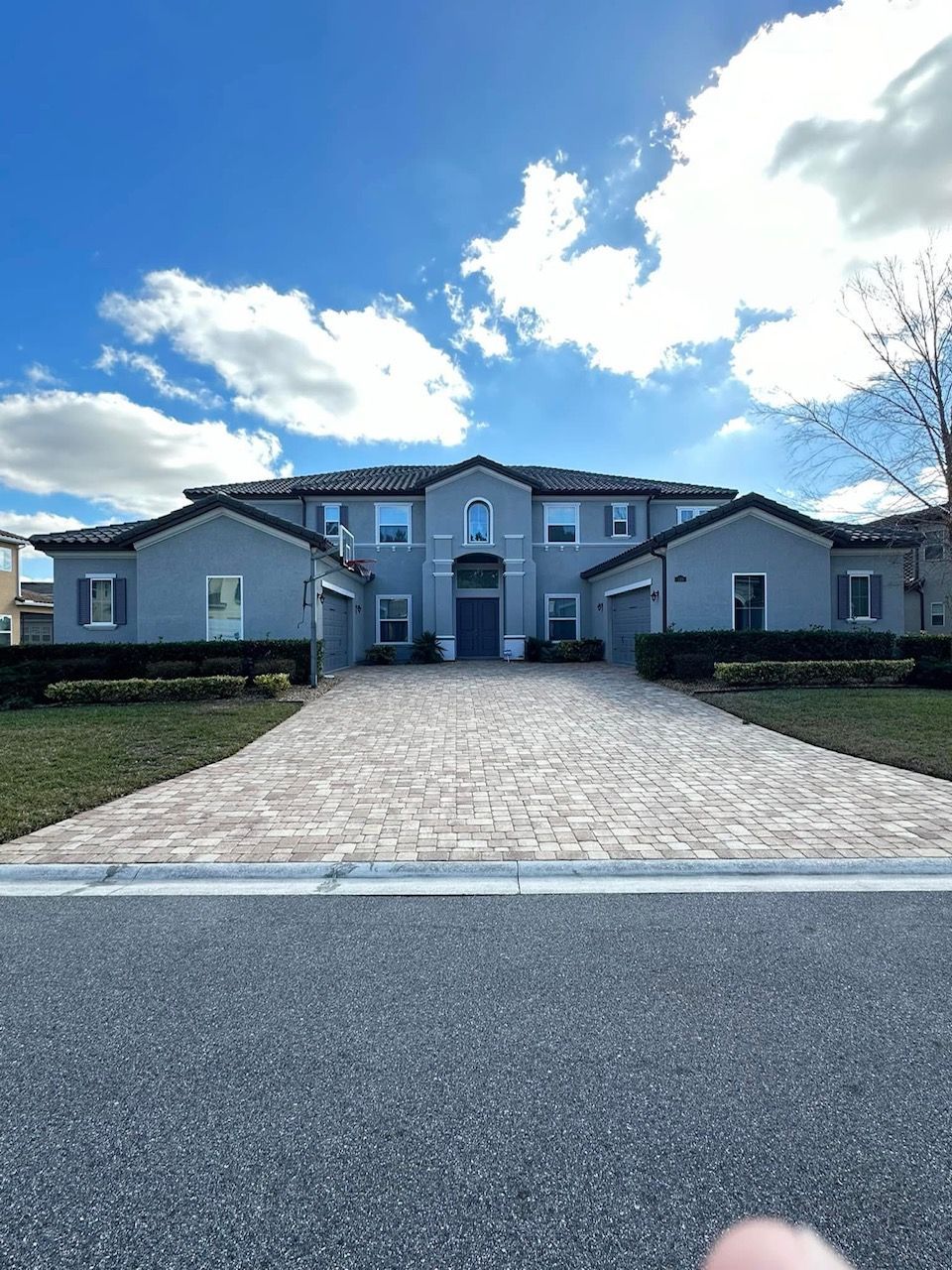 A large house with a brick driveway leading to it