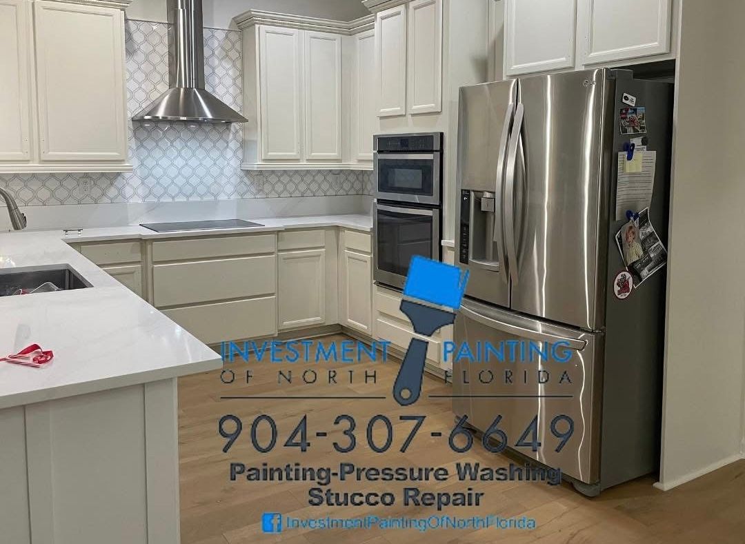 A kitchen with white cabinets and a stainless steel refrigerator.