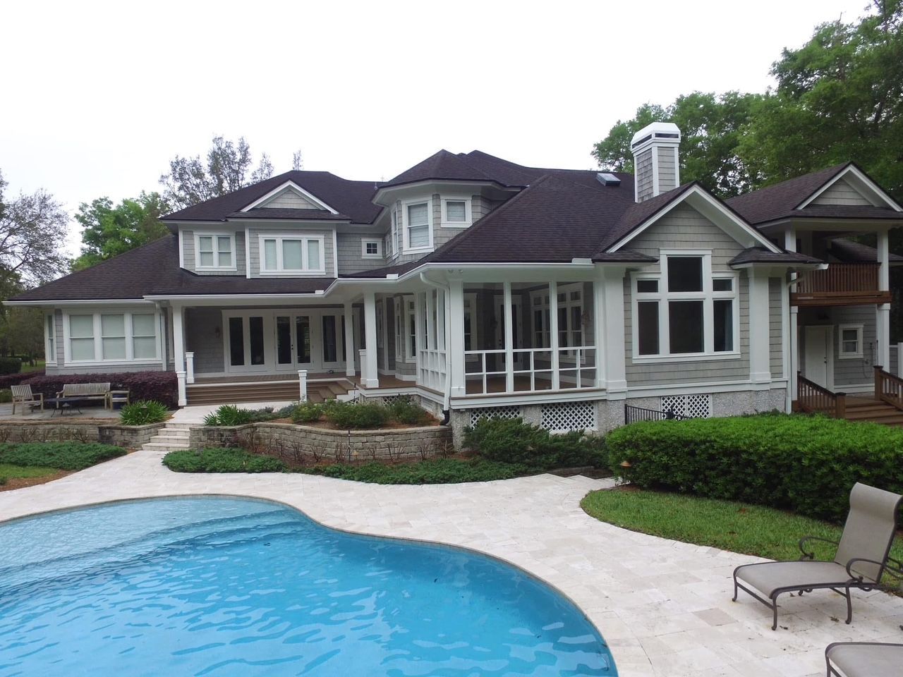 A large house with a swimming pool in front of it