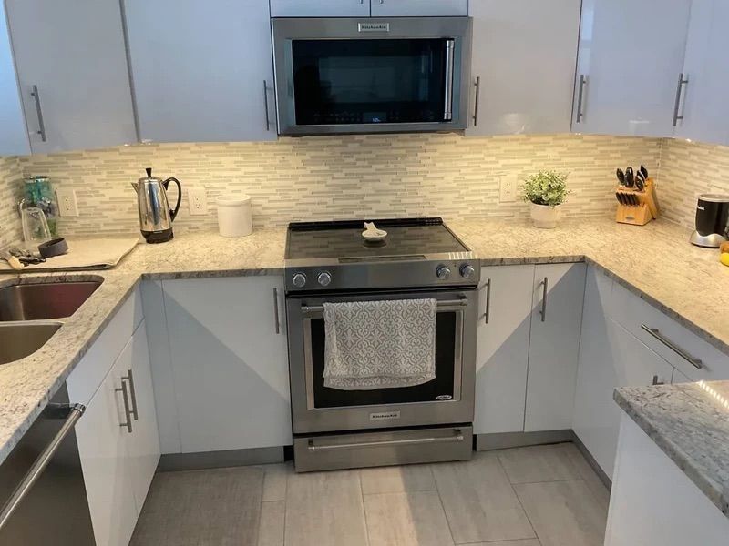 A kitchen with stainless steel appliances and white cabinets