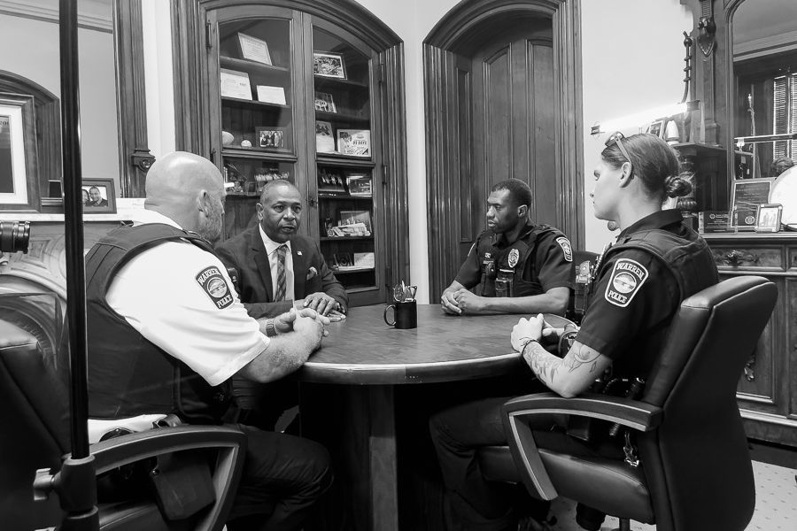 Mayor William F. Franklin and three Warren Police officers sit around a table in a meeting.