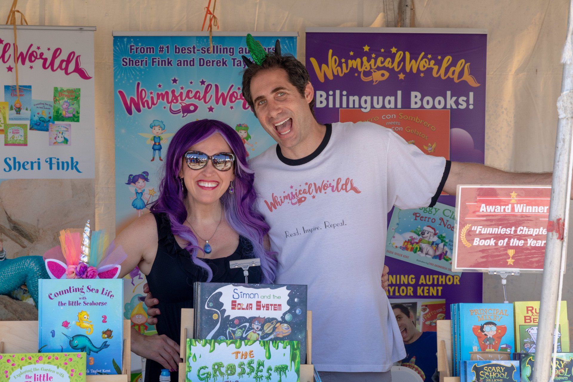 Authors Sheri Fink and Derek Taylor smile inside their booth.