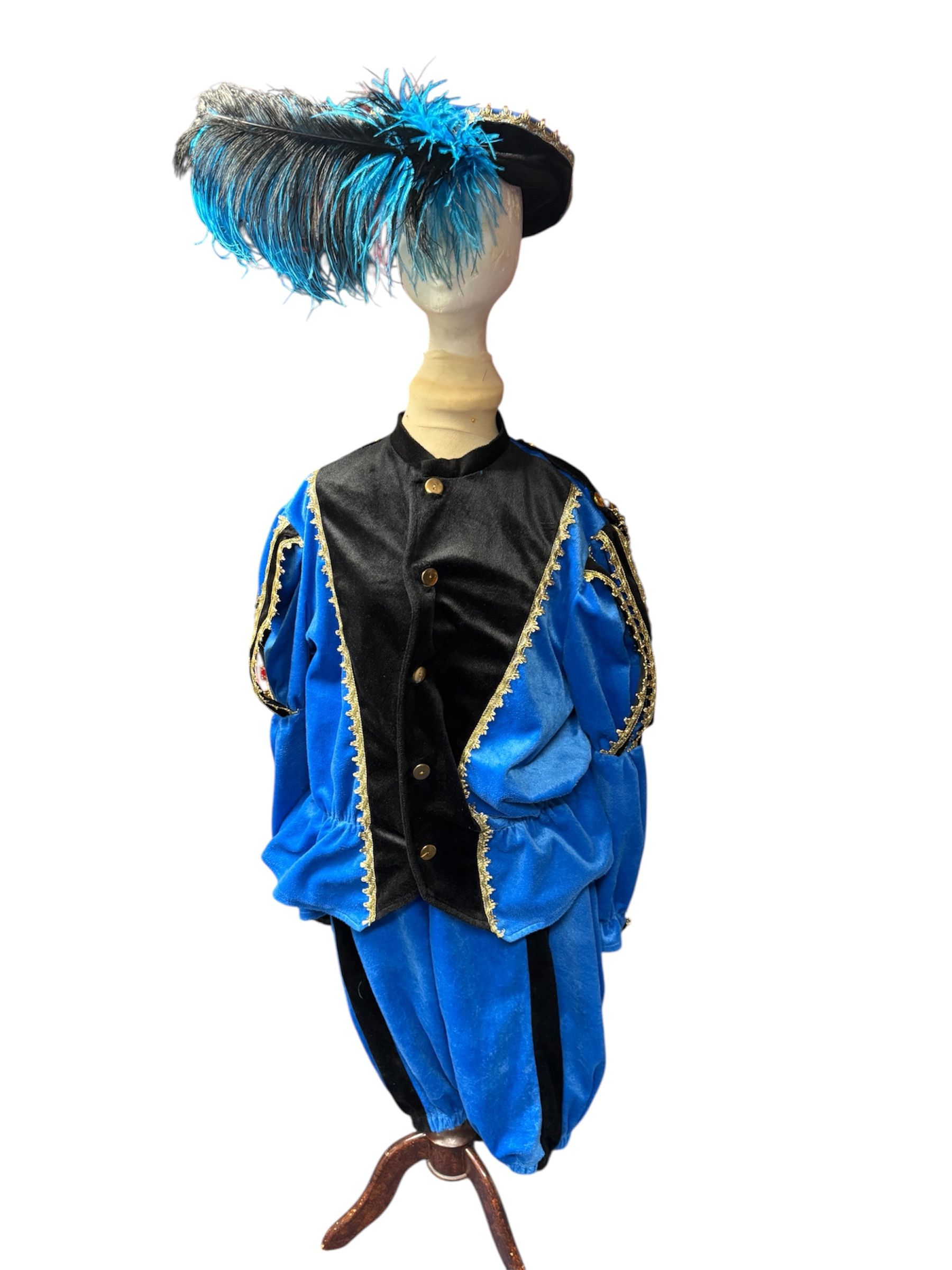 Decoratieve mannequin in een blauw-zwart kostuum met een gevederde hoed en een gedrapeerde jas.