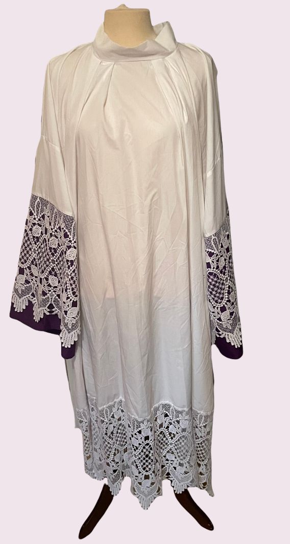 Witte tuniekjurk met lange mouwen en zwarte manchetten en zoom met bloemenprint, op een paspop.