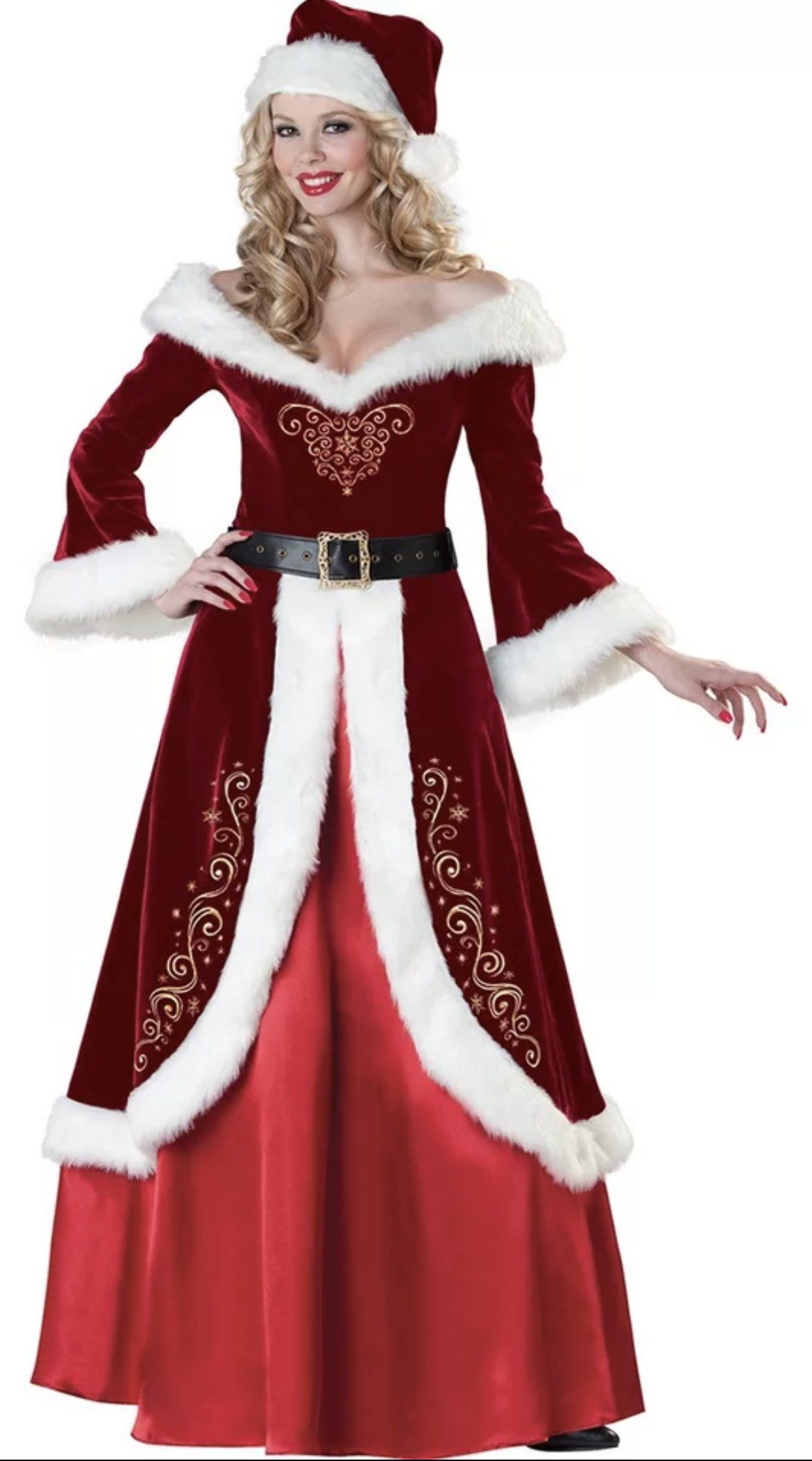 Vrouw in een rood-witte jurk en muts met kerstmanmotief, poserend tegen een witte achtergrond.