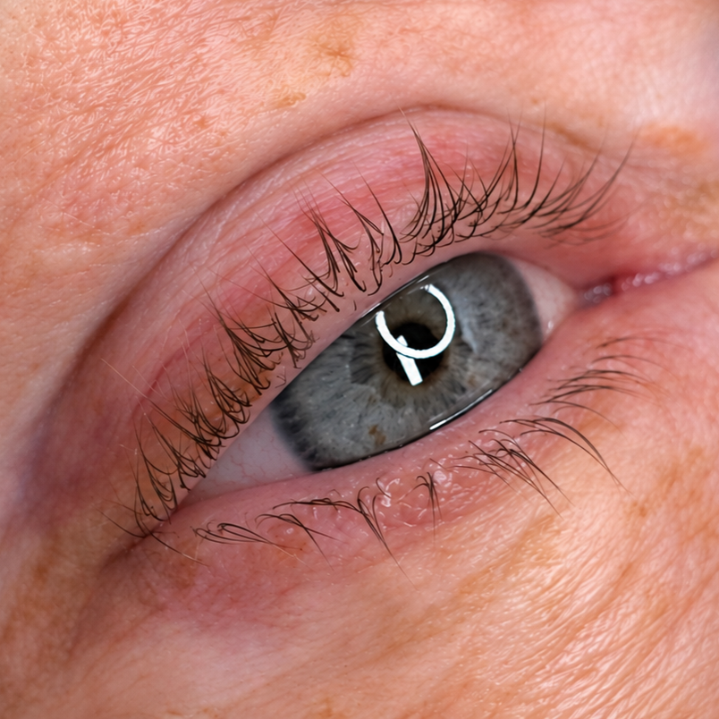Close-up of a gray eye with a ring light reflection and pink eyelids