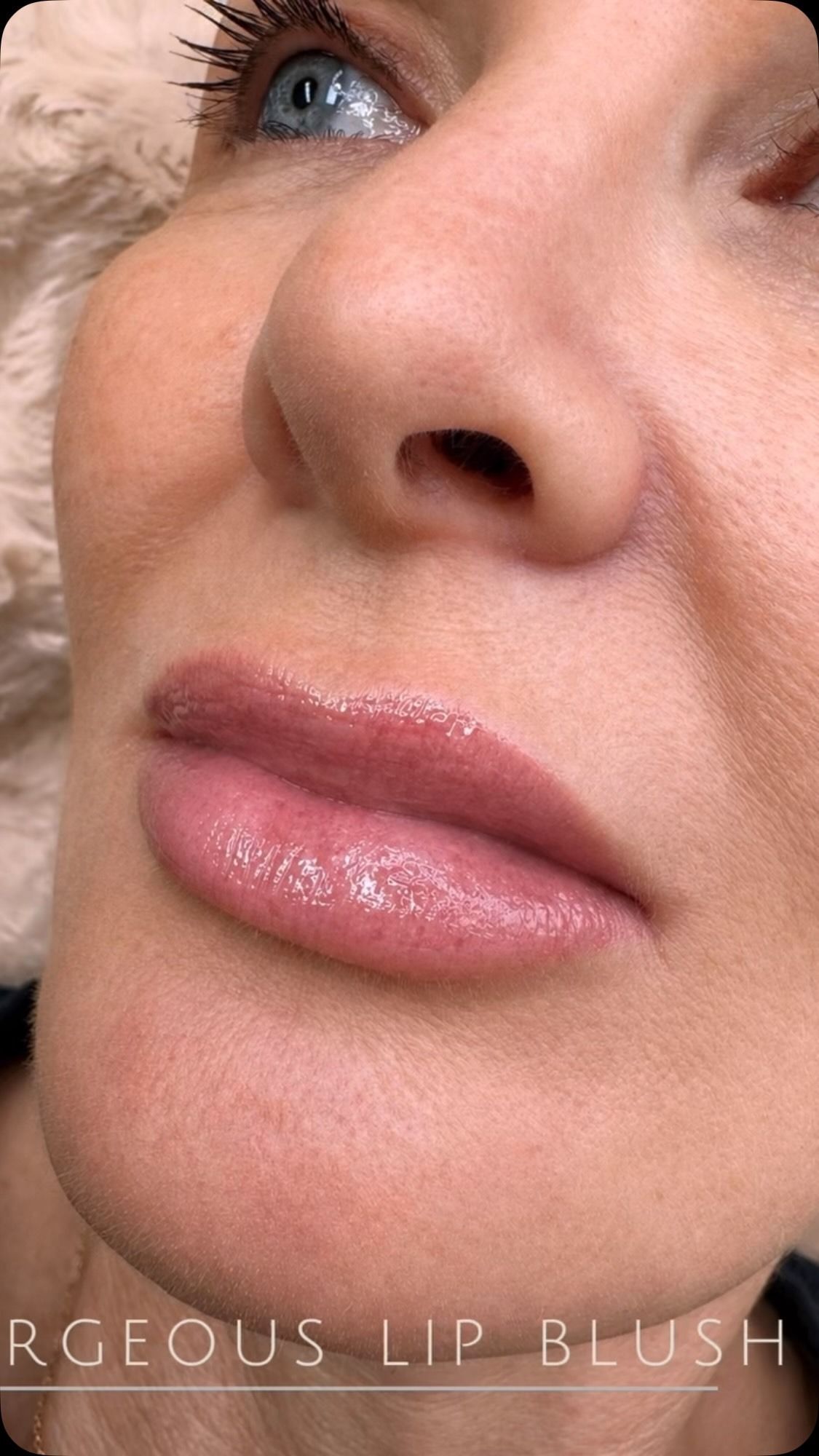 Close-up of lips with glossy pink lip color and subtle blush on the cheek