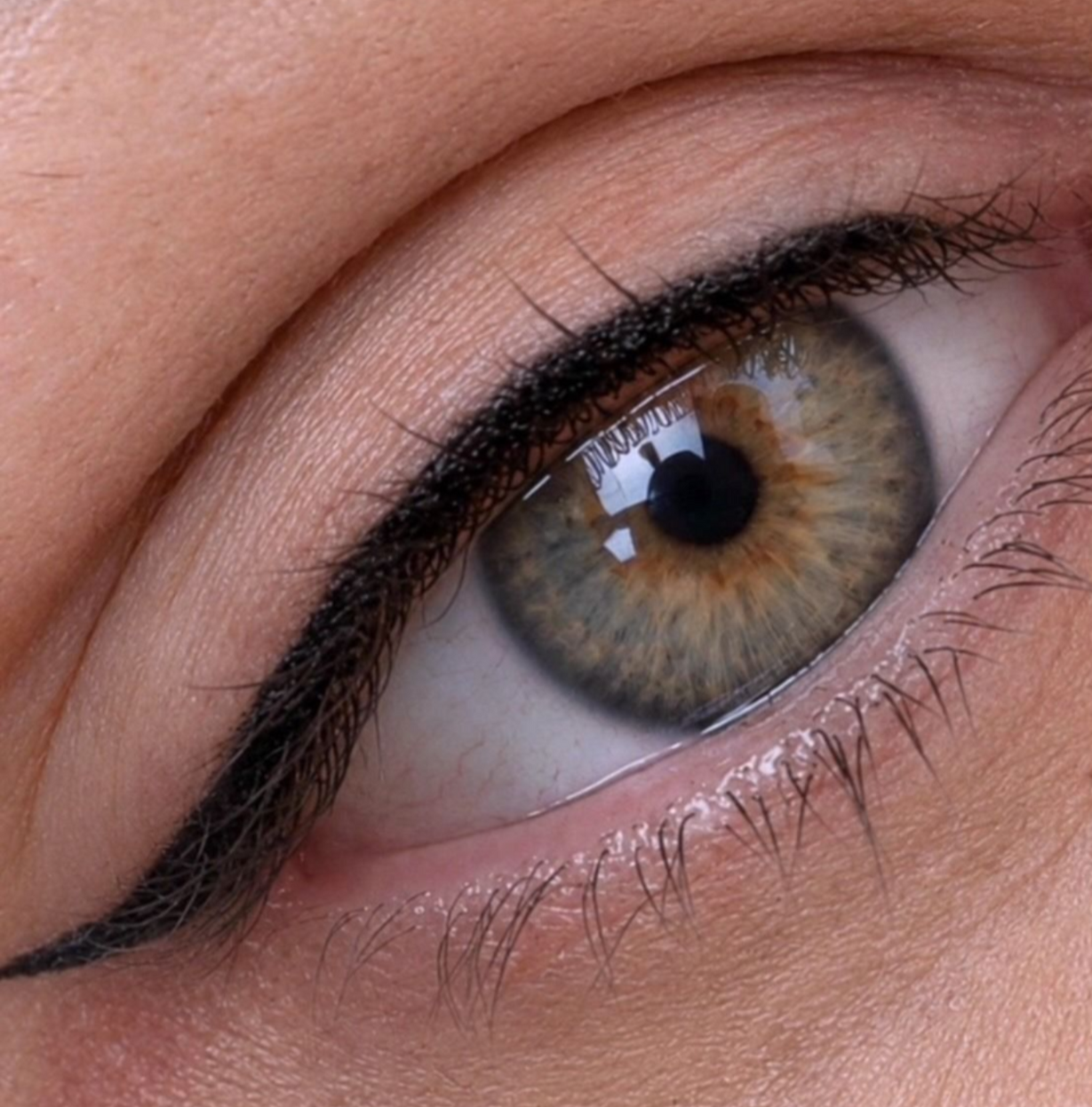 Close-up of a hazel eye with black eyeliner and long eyelashes