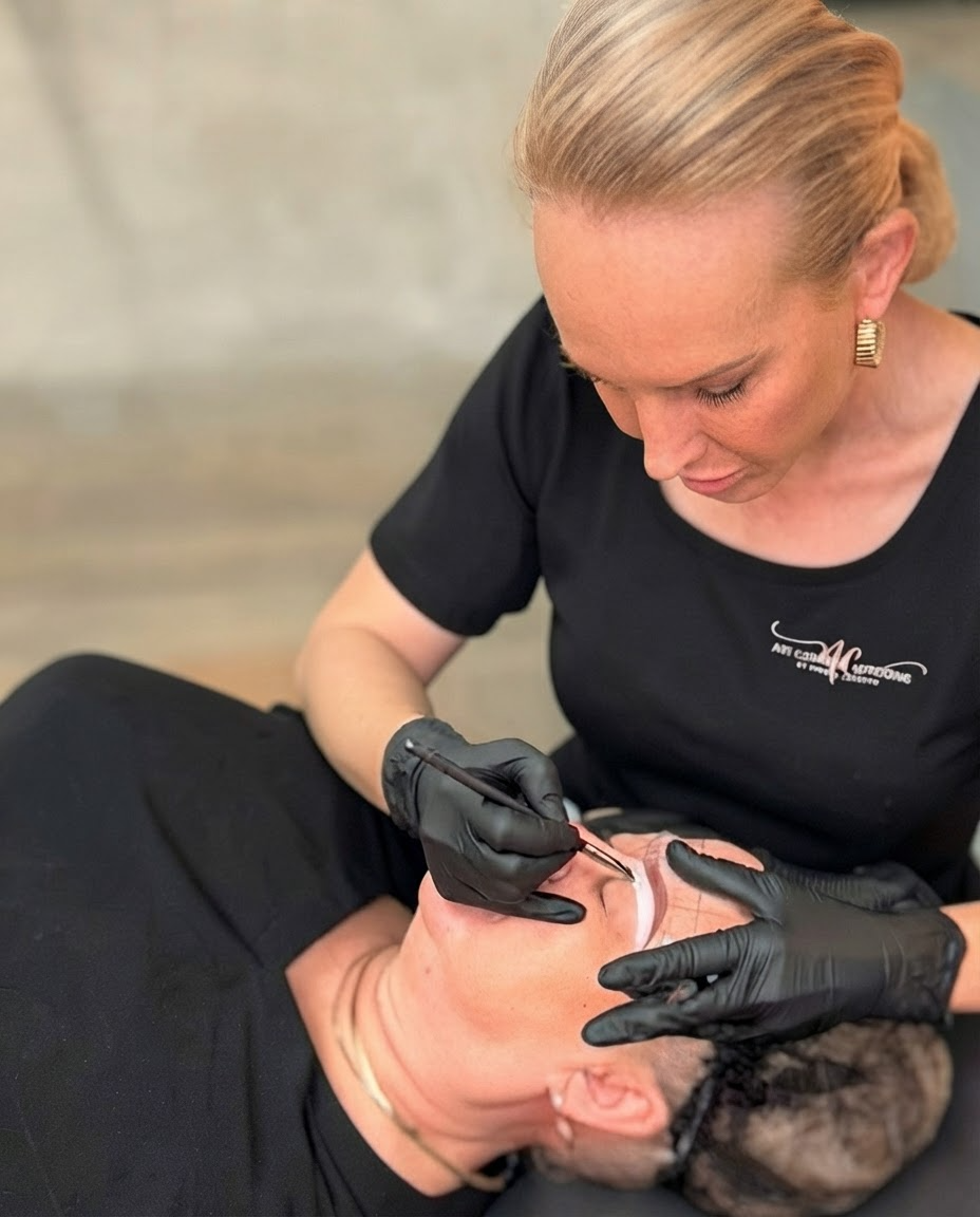 Clinician in black gloves applying treatment to patient’s face in a spa setting