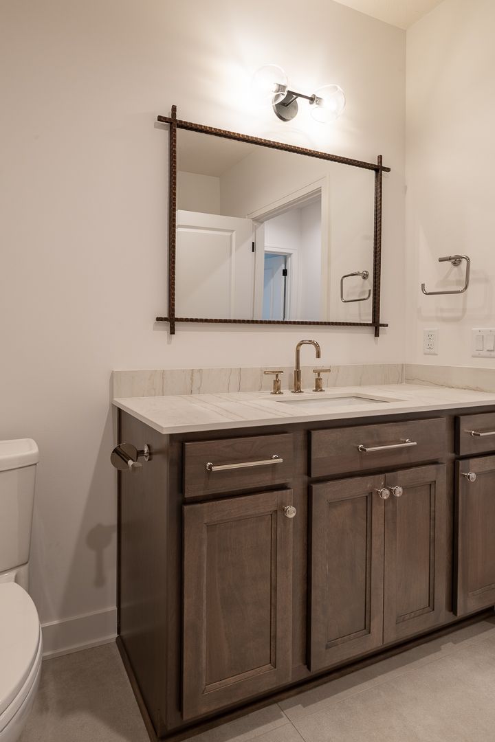 Bathroom With Brown Vanity And Silver Fixtures