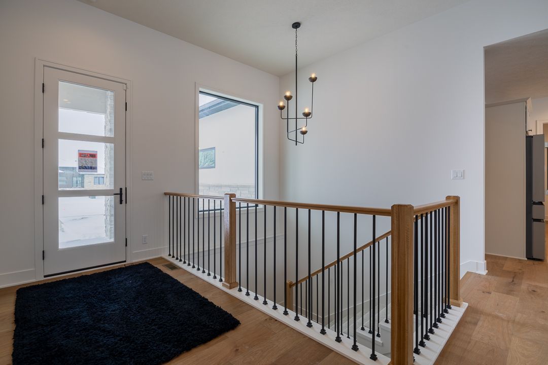Modern Hallway With Staircase And Hardwood Floors
