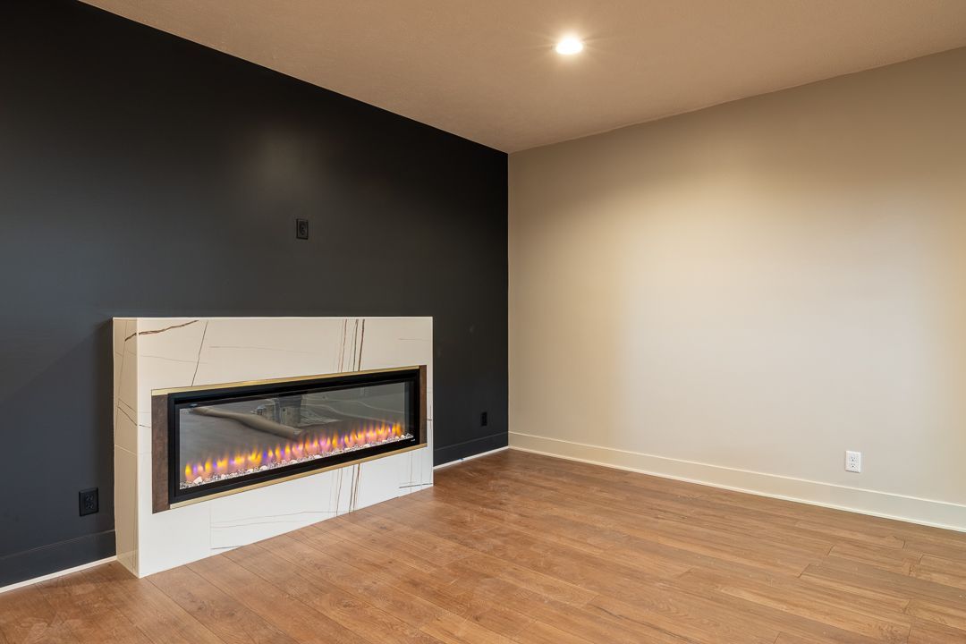 Empty Room With Fireplace And Black Accent Wall
