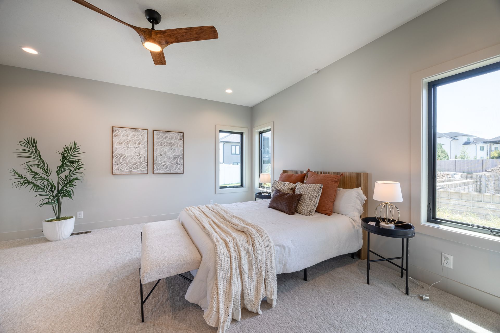 Bedroom With Bed, Side Table, And Windows
