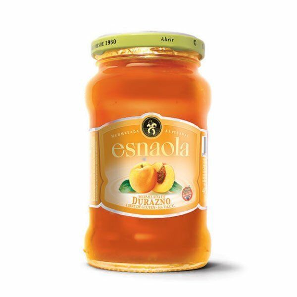 Tarro de mermelada de melocotón Esnaola con conserva de naranja y tapa verde sobre fondo blanco