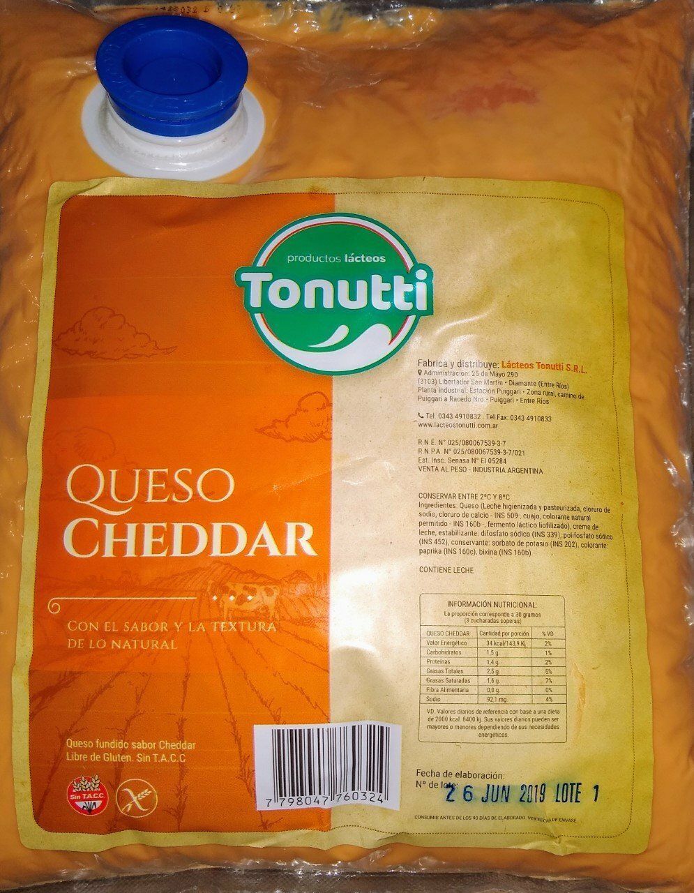 Paquete de queso cheddar Tonutti de color naranja con tapa azul en la parte superior y etiqueta nutricional a la derecha.