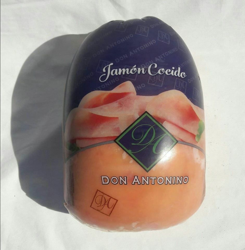 Jamón cocido envasado en papel morado y melocotón con la etiqueta Don Antonino.