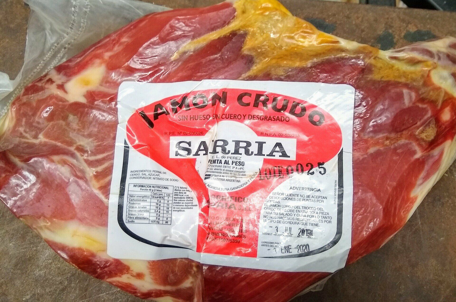 Paquete de carne roja envasado al vacío con la etiqueta “Sarria” y una etiqueta blanca y roja.