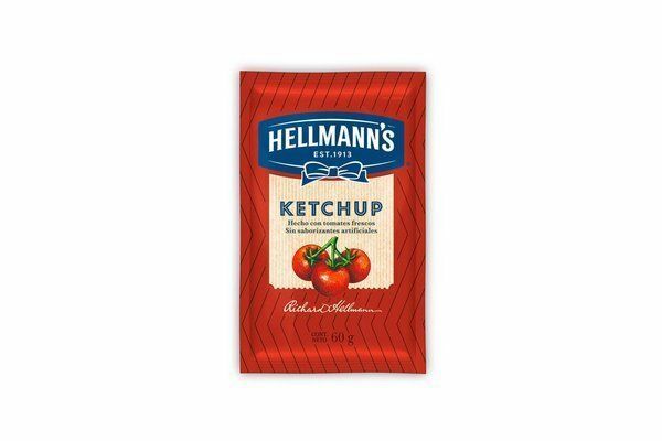 Paquete de kétchup Hellmann's con tomates sobre fondo rojo