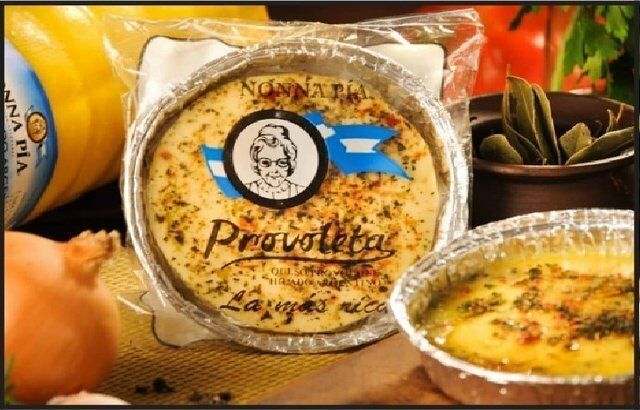 Quiche horneada en moldes de aluminio con envases redondos etiquetados, rodeada de cebollas y verduras.